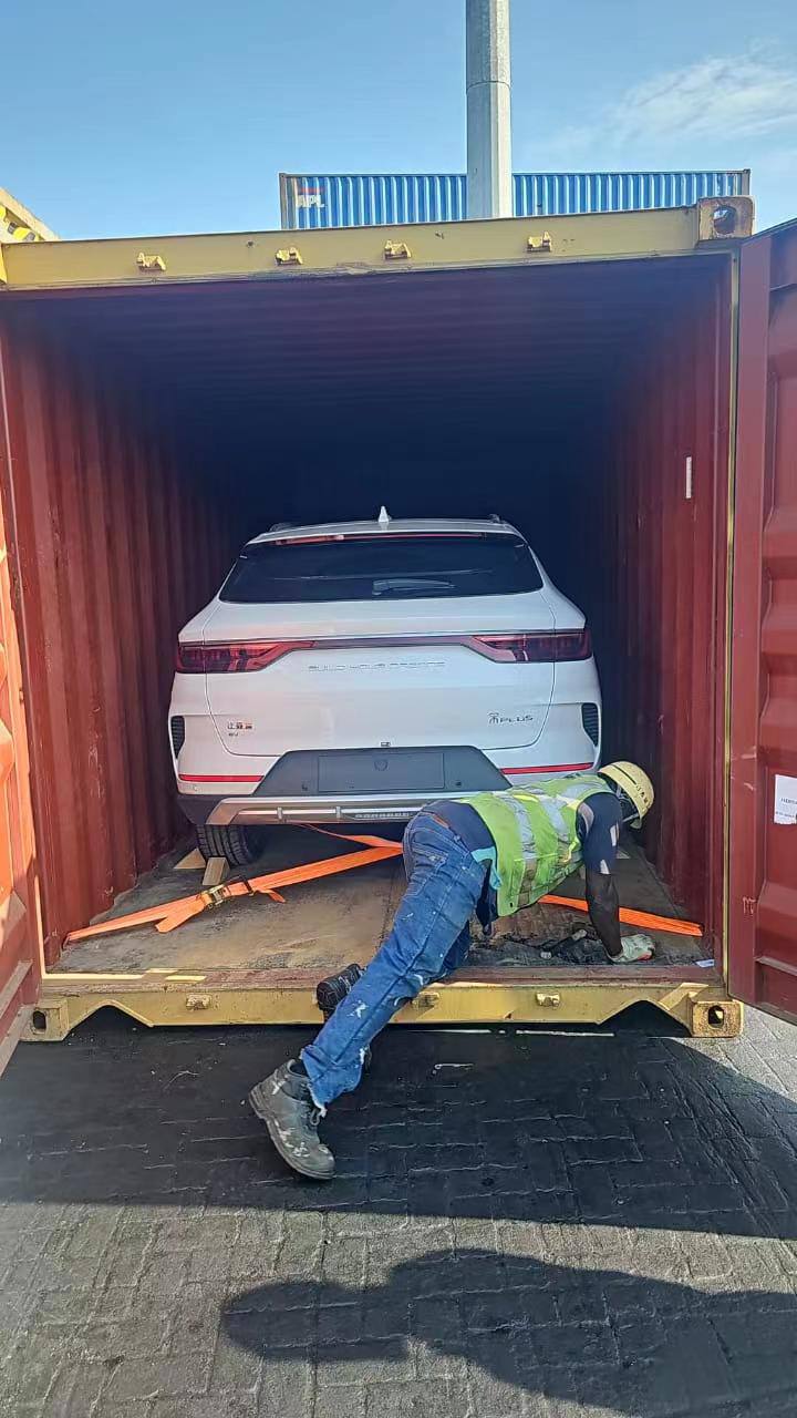 Electric vehicle being loaded into a shipping container for export
